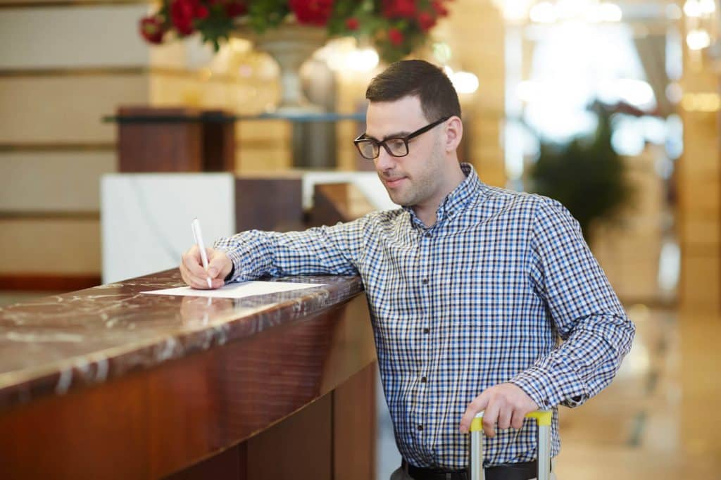 A customer filling out a feedback form at a hotel front desk